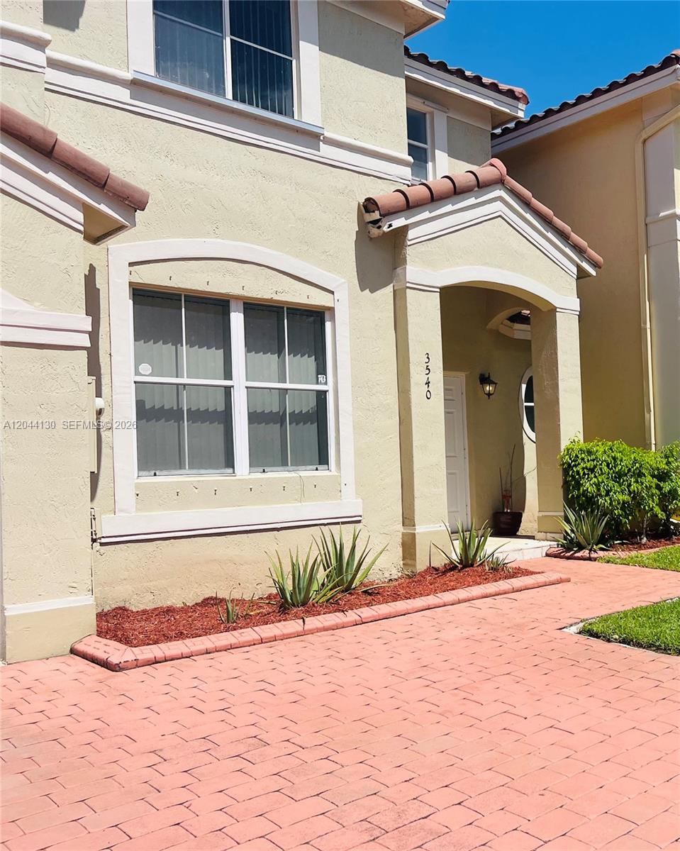 The exterior of a two-story stucco house features a tiled roof and a paved walkway — 3540 SW 170th Ave # 0, Miramar FL 33027, MIRAMAR, FL