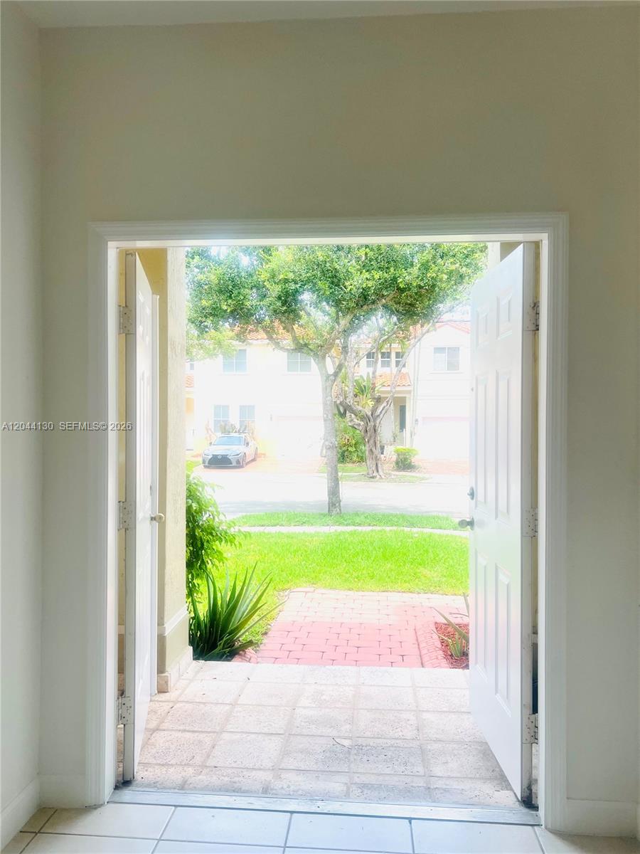 An open doorway reveals a tiled entryway looking out onto a residential street and lawn — 3540 SW 170th Ave # 0, Miramar FL 33027, MIRAMAR, FL