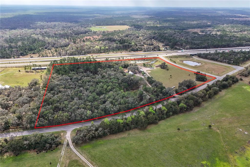 An aerial view shows a large, partially wooded plot of land outlined in red — 28130 CYPRESS MILL ROAD, SORRENTO, FL
