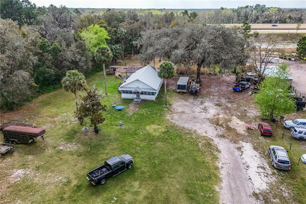 An aerial view shows a white house on a large, grassy lot with several vehicles — 28130 CYPRESS MILL ROAD, SORRENTO, FL