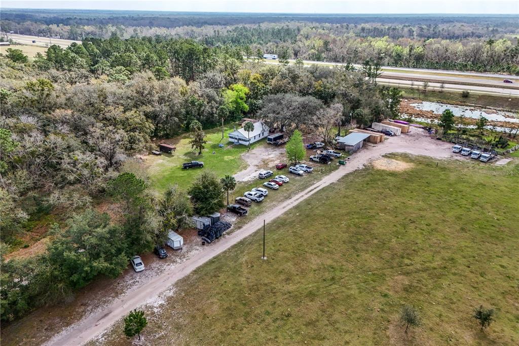 An aerial view shows a rural property with a house, outbuildings, and several parked vehicles — 28130 CYPRESS MILL ROAD, SORRENTO, FL