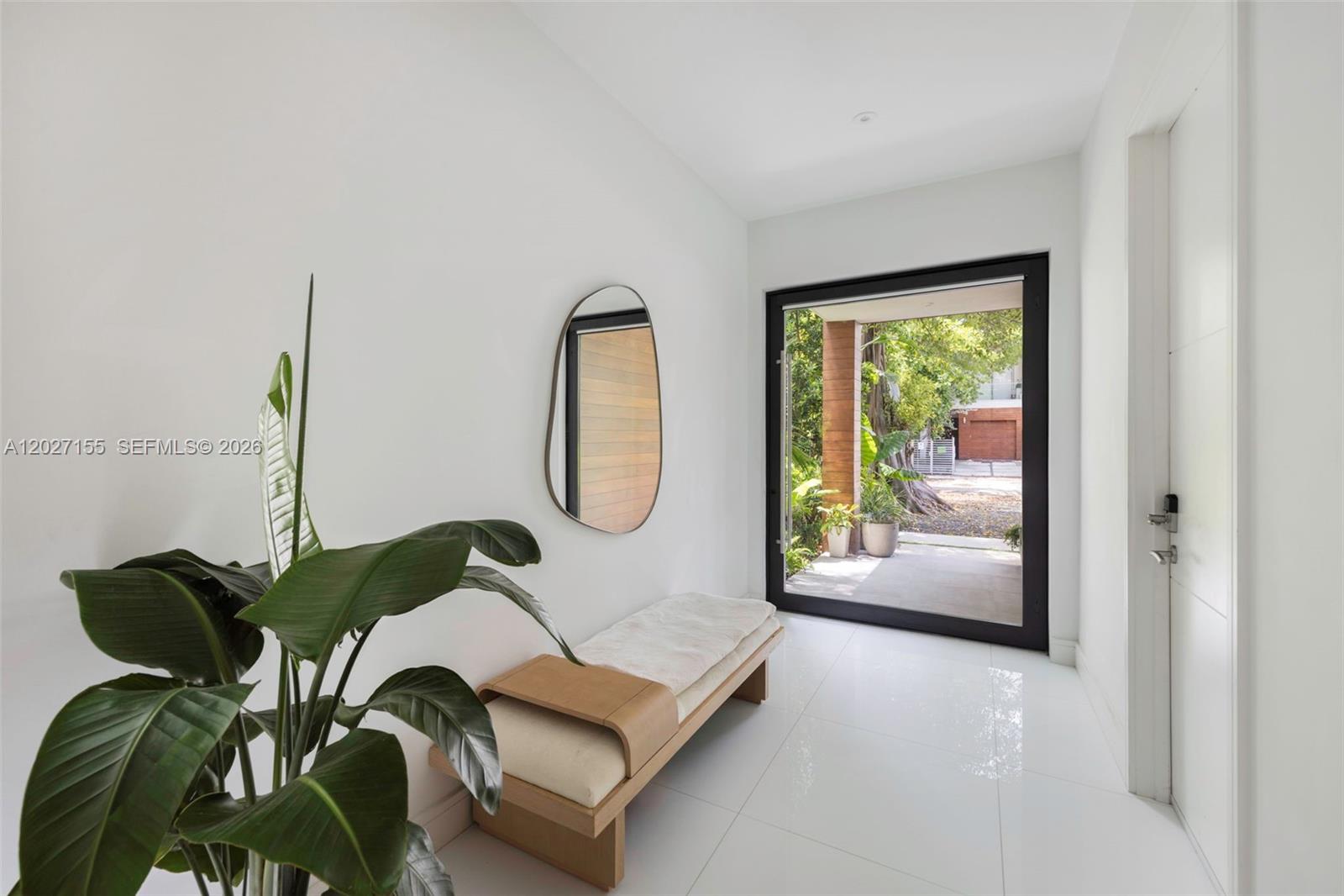 A bright entryway features white tile floors, a wooden bench, a mirror, and a glass door — 2986 Coconut Ave, Coconut Grove FL 33133, COCONUT GROVE, FL