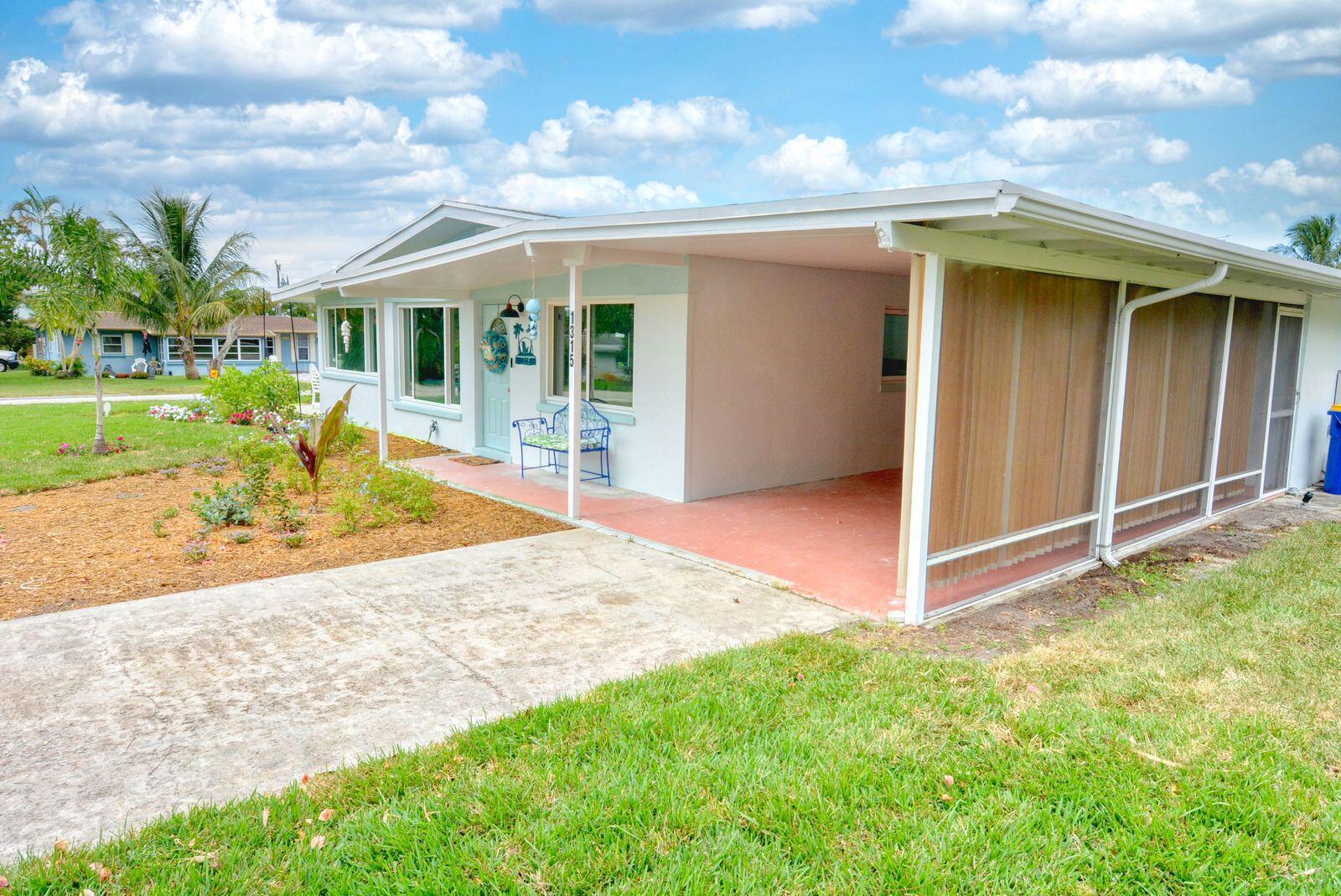 A single-story house with a carport, screened-in porch, and a landscaped front yard — 1315 NE Flora Place, Jensen Beach FL 34957, JENSEN BEACH, FL