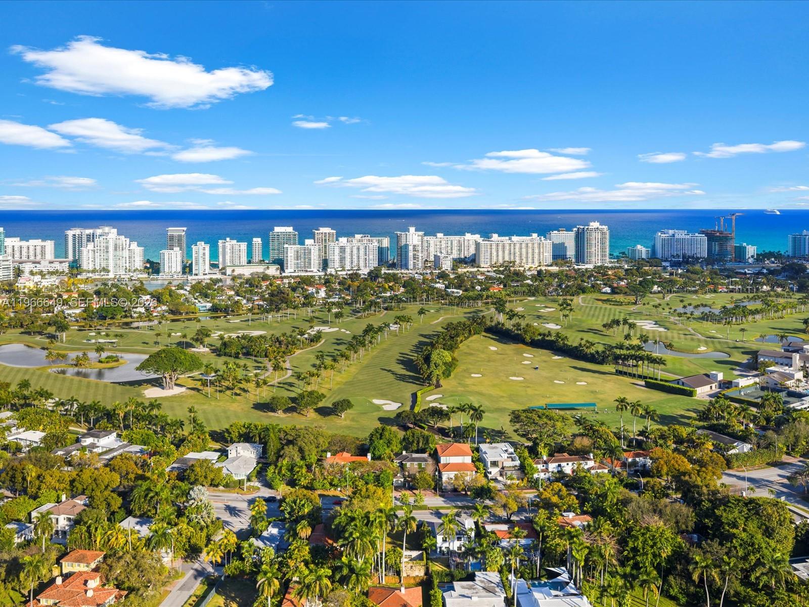 An aerial view shows a golf course surrounded by residential homes and a coastal skyline — 5838 Alton Rd, Miami Beach FL 33140, MIAMI BEACH, FL