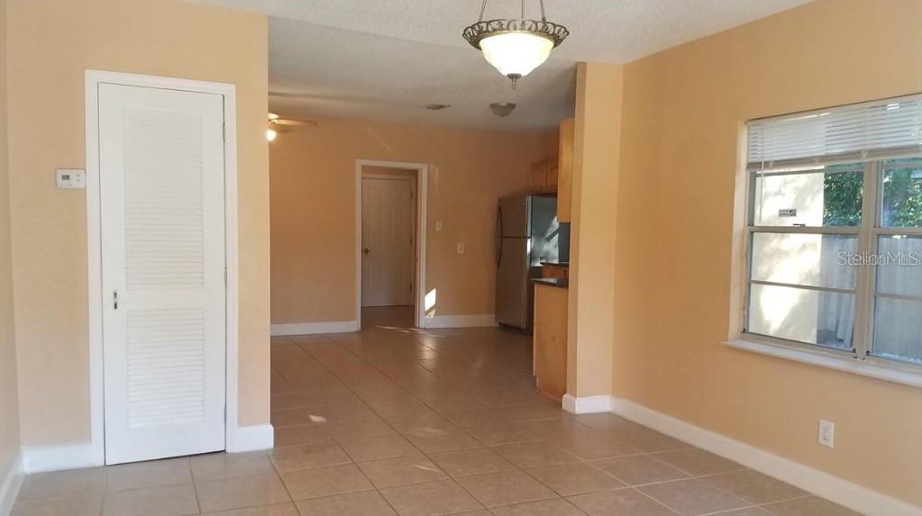 A room with light-colored tile floors, peach walls, a ceiling light fixture, and a window — 2921 W WALNUT STREET, TAMPA, FL