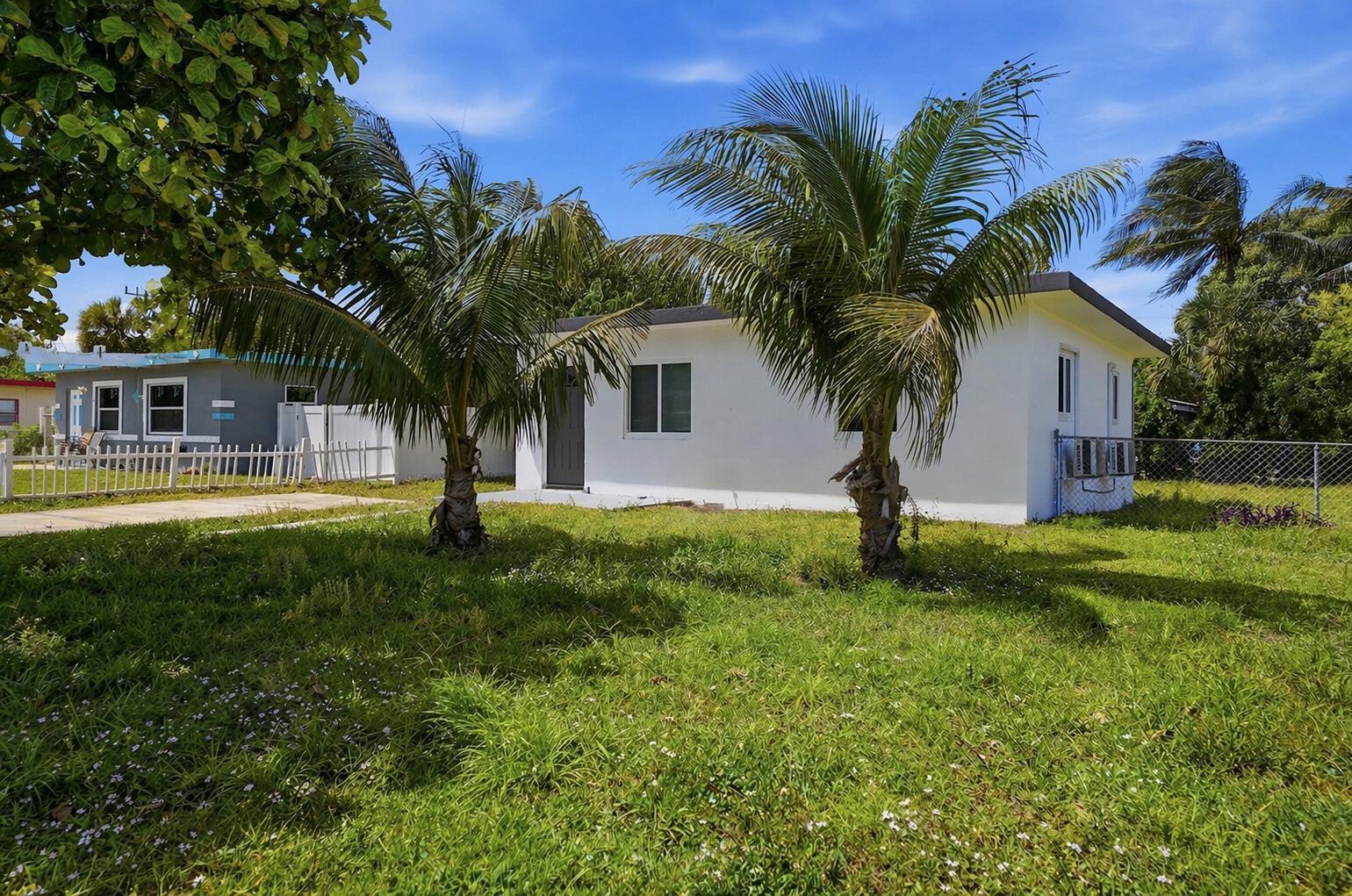 A white single-story house sits on a grassy lot with two palm trees in front — 2625 NW 10th Street, Pompano Beach FL 33069, POMPANO BEACH, FL