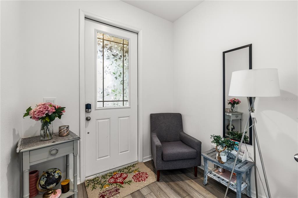 A kitchen features white cabinets, granite countertops, a center island with seating, and stainless appliances — 16461 PRAIRIE SCHOOL DRIVE, WINTER GARDEN, FL