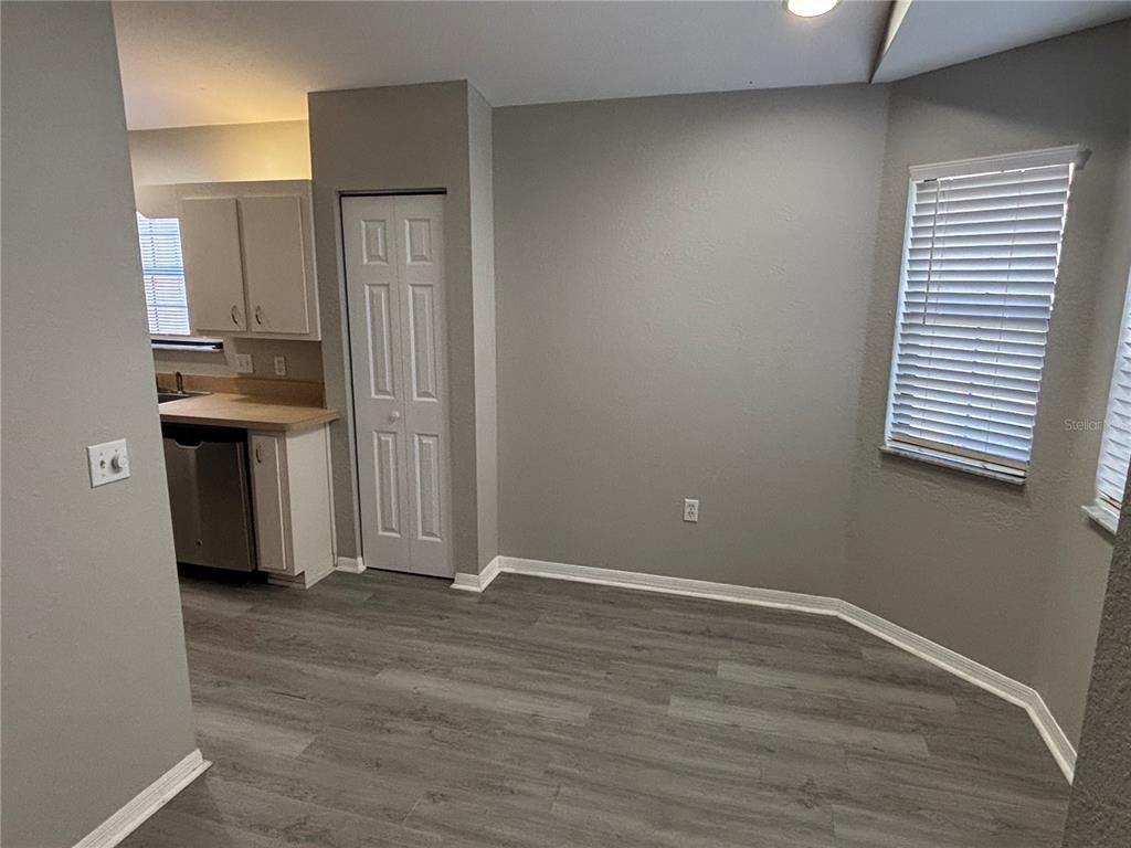 A dining area with gray walls, wood-look flooring, a white closet door, and two windows — 3906 NE 22ND STREET, OCALA, FL
