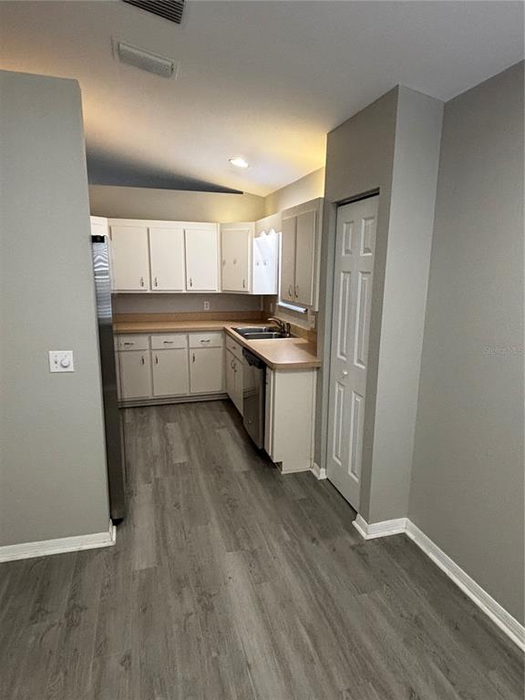A kitchen with white cabinets, light countertops, and grey wood-look flooring — 3906 NE 22ND STREET, OCALA, FL