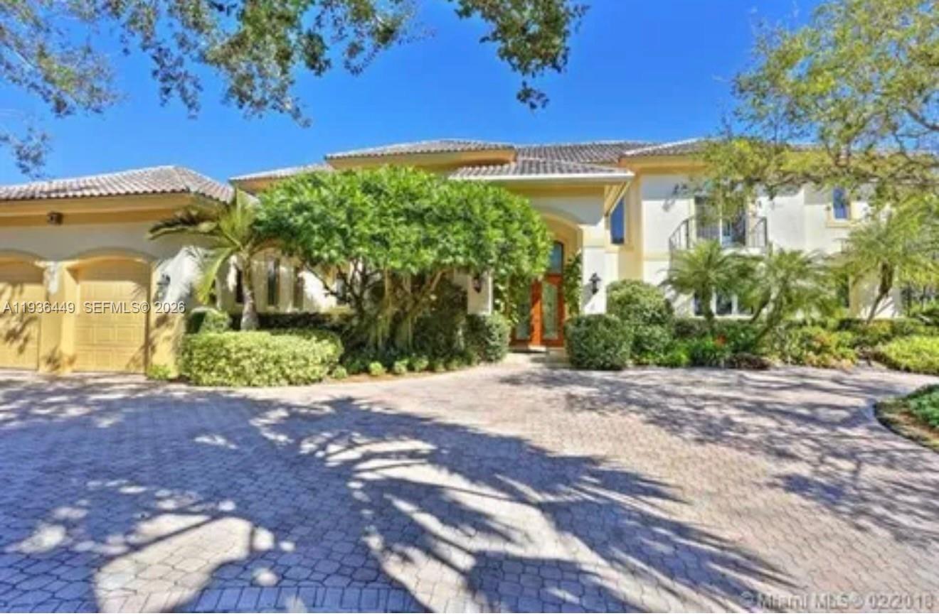 A two-story Mediterranean-style house with a paved circular driveway and a three-car garage — 673 Destacada Ave, Coral Gables FL 33156, CORAL GABLES, FL