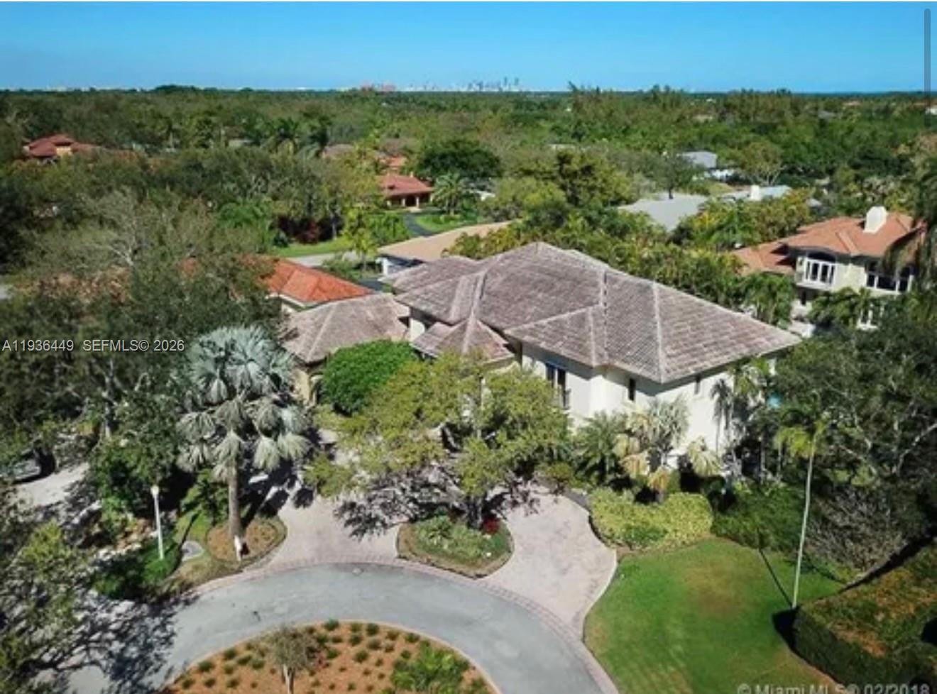 An aerial view shows a large house with a tiled roof and a circular driveway — 673 Destacada Ave, Coral Gables FL 33156, CORAL GABLES, FL