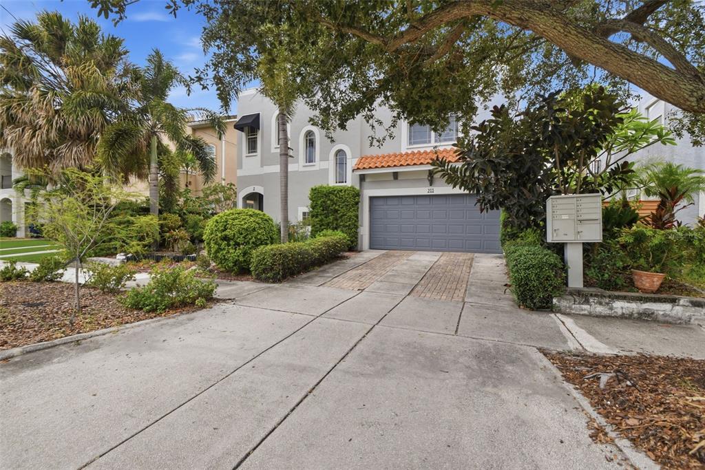 This virtual staging shows a living room with light wood flooring, a sofa, and chairs — 211 S WESTLAND AVENUE UNIT 1, TAMPA, FL