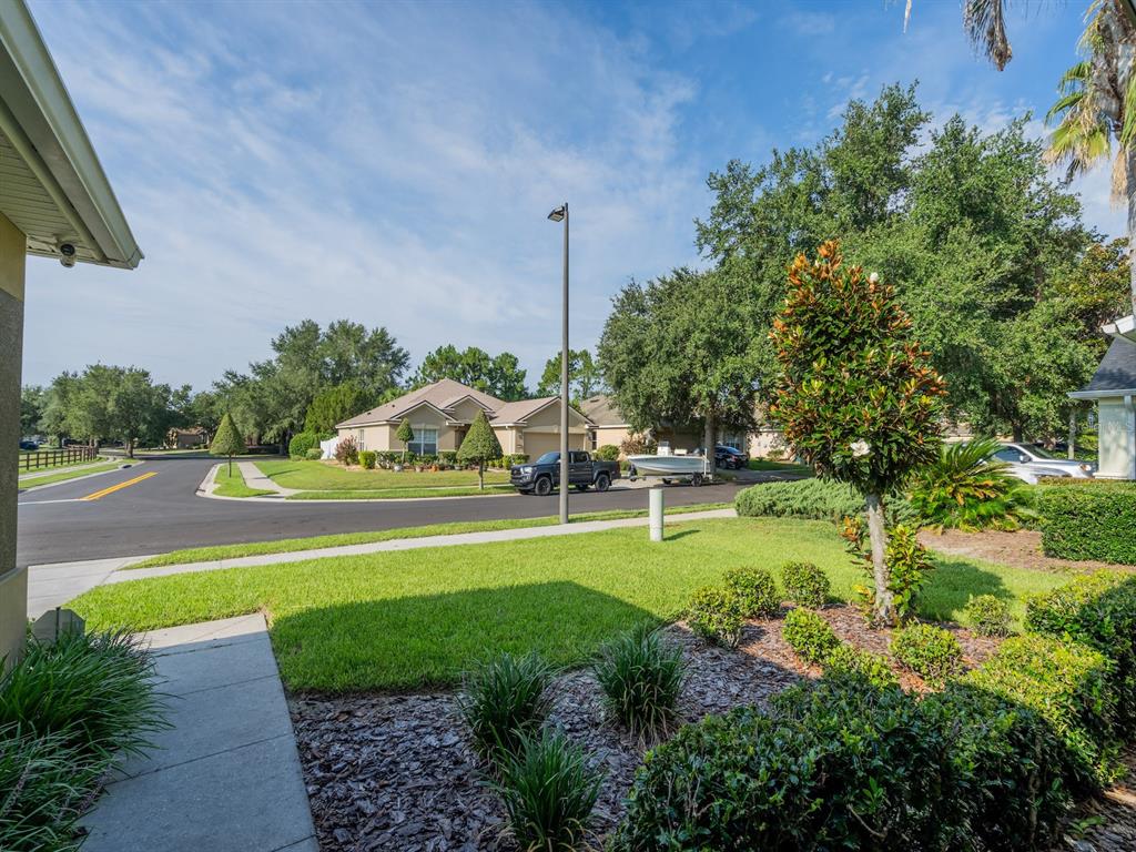 A view from a residential driveway looking toward a suburban street with houses and trees — 5177 SW 39TH STREET, OCALA, FL