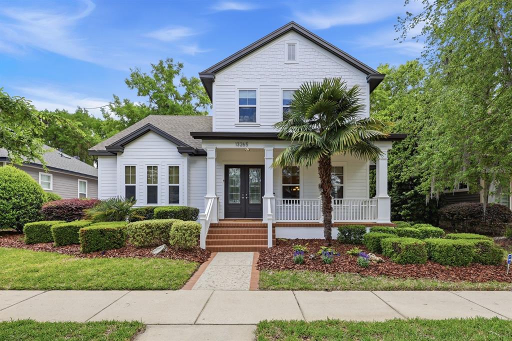 A two-story white house with a front porch, a palm tree, and a landscaped yard — 13265 SW 6TH AVENUE, NEWBERRY, FL
