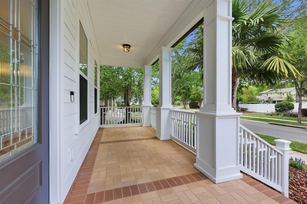 A white house exterior features a covered front porch with columns, steps, and double doors — 13265 SW 6TH AVENUE, NEWBERRY, FL