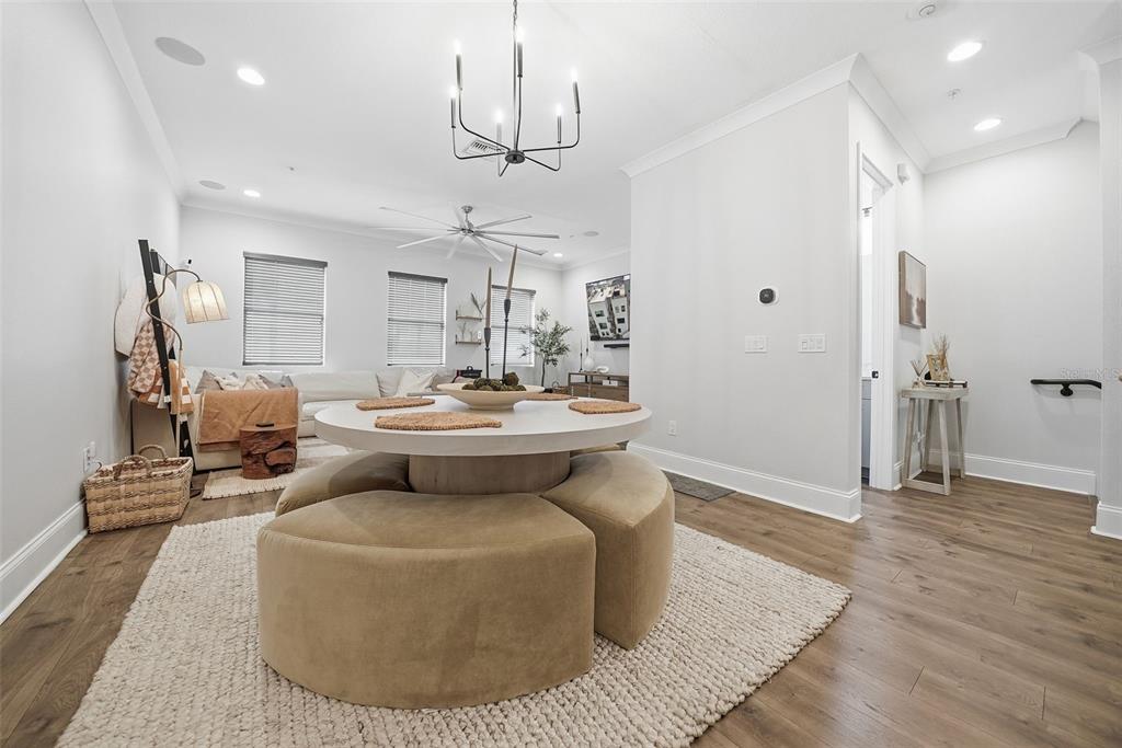 A dining area features a round table with upholstered ottomans on a textured rug — 2511 N GRADY AVENUE UNIT 91, TAMPA, FL