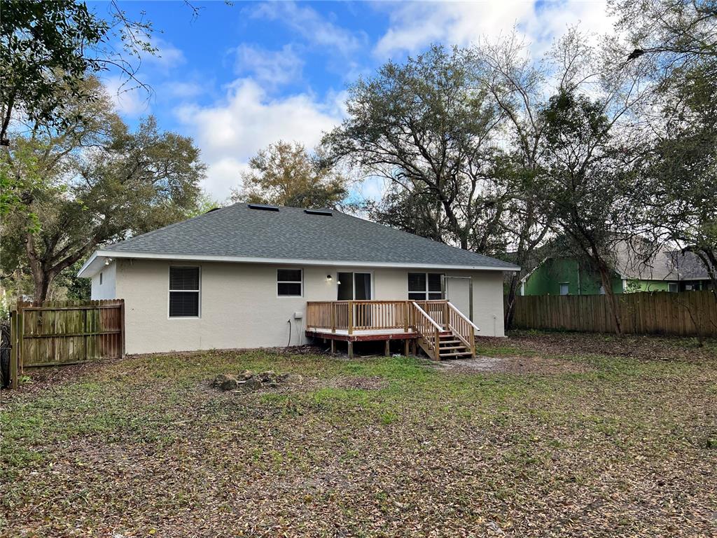 The rear exterior of a house features a wooden deck and a fenced backyard — 2336 W ORANGE ROAD, DELAND, FL