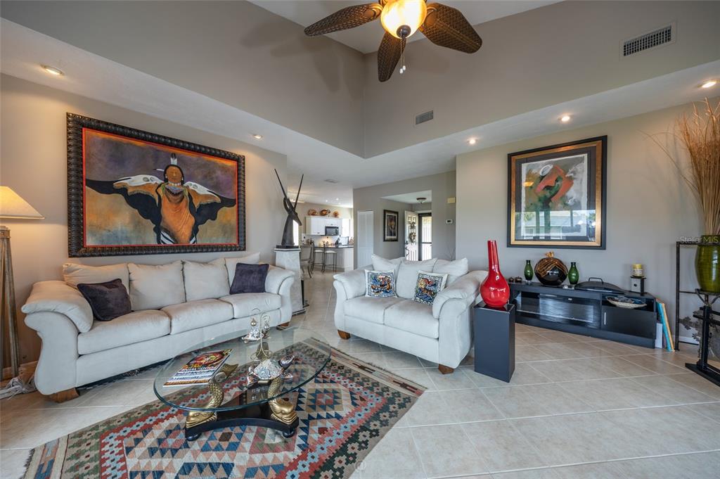 A living room features two white sofas, a glass coffee table, and large framed artwork — 11 MAGNOLIA DRIVE S UNIT 11, ORMOND BEACH, FL