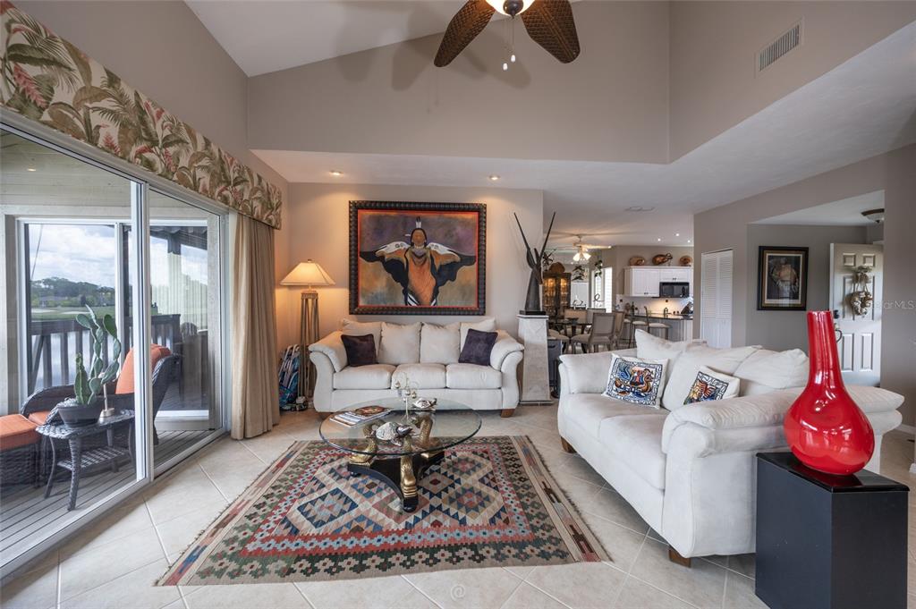 A living room features two white sofas, a glass coffee table, and a patterned rug — 11 MAGNOLIA DRIVE S UNIT 11, ORMOND BEACH, FL