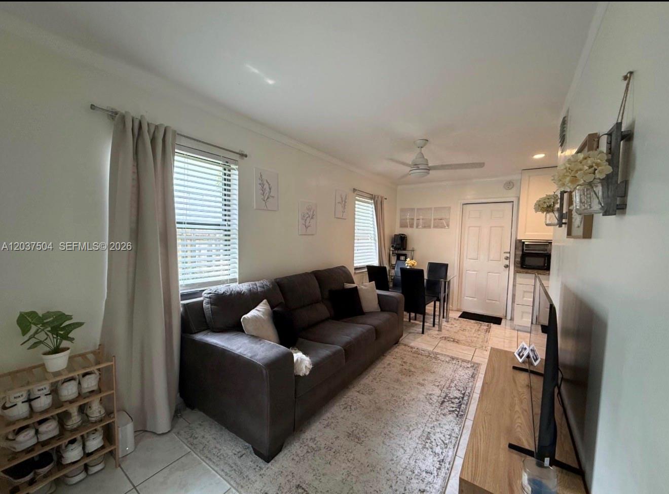 A living room features a dark sofa, a dining area, and a shoe rack — 612 W Drew St, Lantana FL 33462, LANTANA, FL