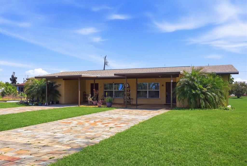 A single-story house with a paved driveway, covered porch, and a large front lawn — 12125 MARGARITA AVENUE, NORTH PORT, FL