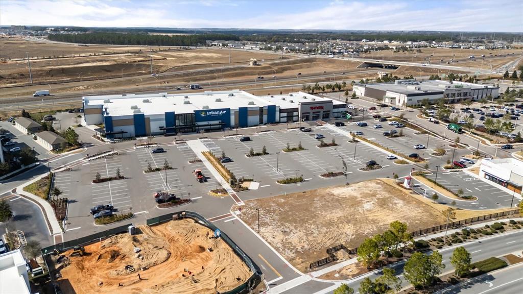 An aerial view shows a commercial shopping center with a large parking lot and construction — 5758 HAMLIN GROVES TRAIL, WINTER GARDEN, FL