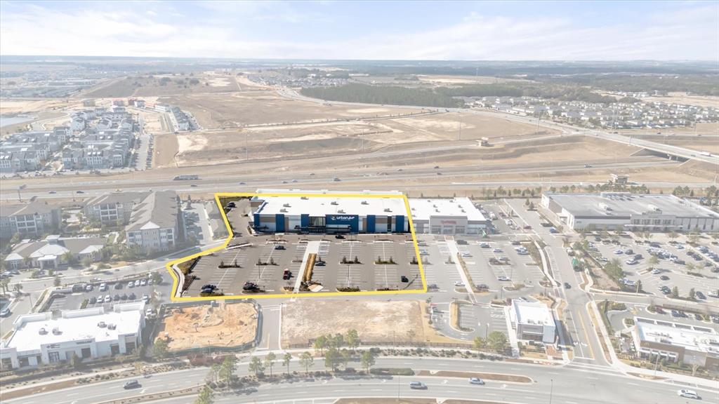An aerial view shows a commercial building with a large parking lot outlined in yellow — 5758 HAMLIN GROVES TRAIL, WINTER GARDEN, FL