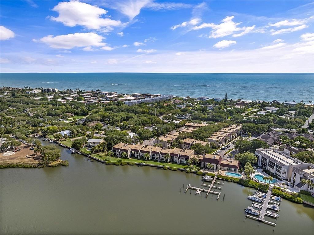 An aerial view shows a coastal residential complex with a boat dock on the water — INDIAN RIVER SHORES, FL