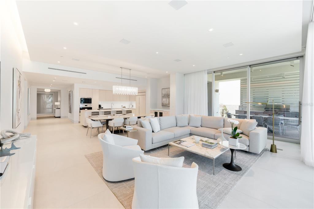 A bright, open-concept living and dining area features white furniture, marble flooring, and large windows — Ocean Drive FOUR SEASONS PRIVATE RESIDENCES UNIT 6302, RIO GRANDE, PR