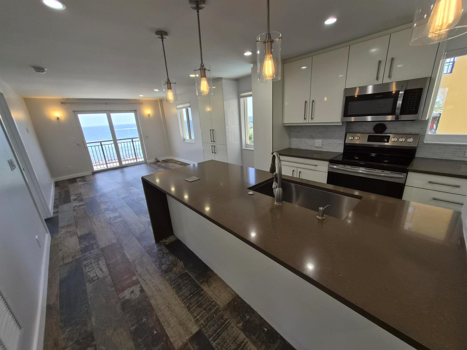 A modern kitchen with a large island overlooks a living area with ocean views — 1815 N Surf Road # 404, Hollywood FL 33019, HOLLYWOOD, FL