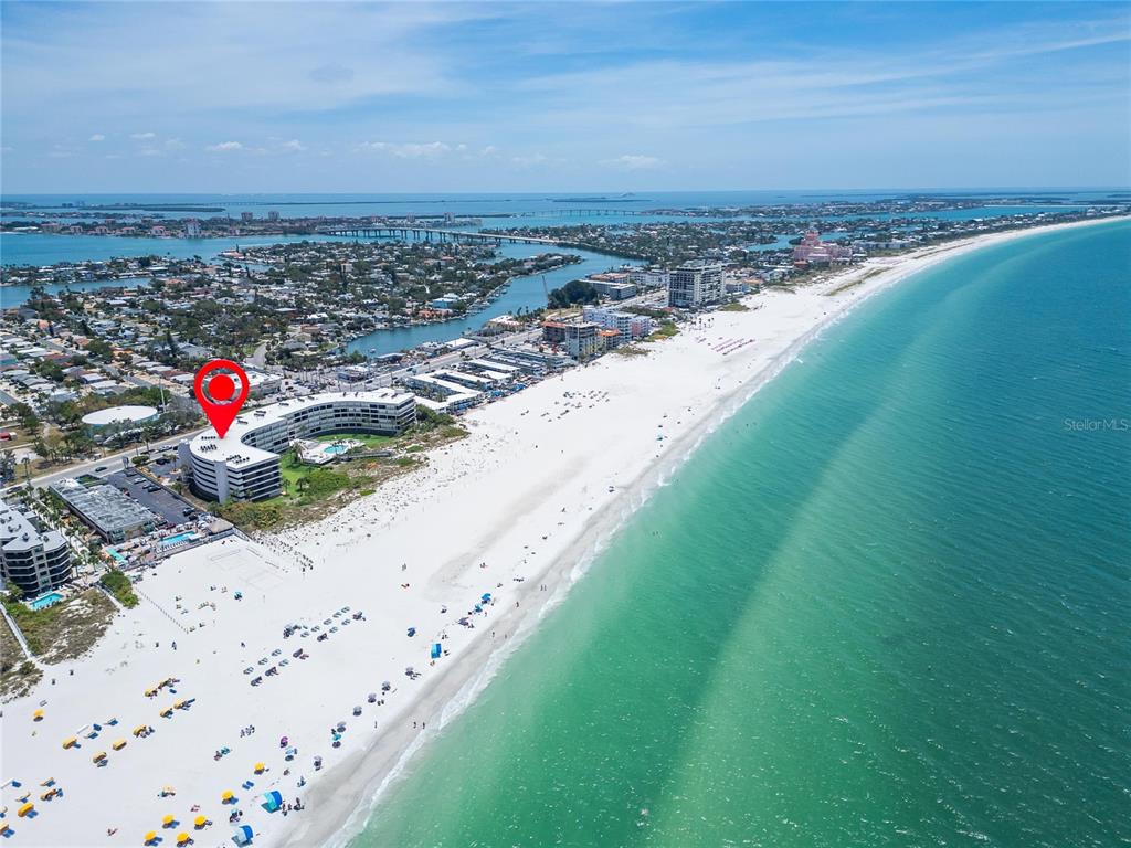 An aerial view shows a white beachfront hotel with a red location pin — 4450 GULF BOULEVARD UNIT 113, ST PETE BEACH, FL