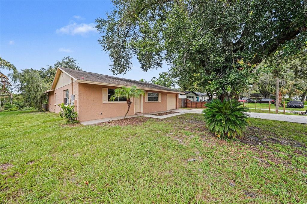 A single-story house with a tan stucco exterior, a shingled roof, and a concrete driveway — 2451 GLENVIEW DRIVE, LAND O LAKES, FL