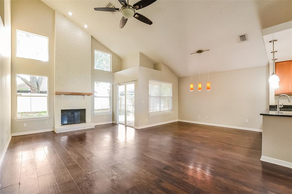A living room with dark wood floors, a white brick fireplace, and vaulted ceilings — 1347 BLACK WILLOW TRAIL, ALTAMONTE SPRINGS, FL