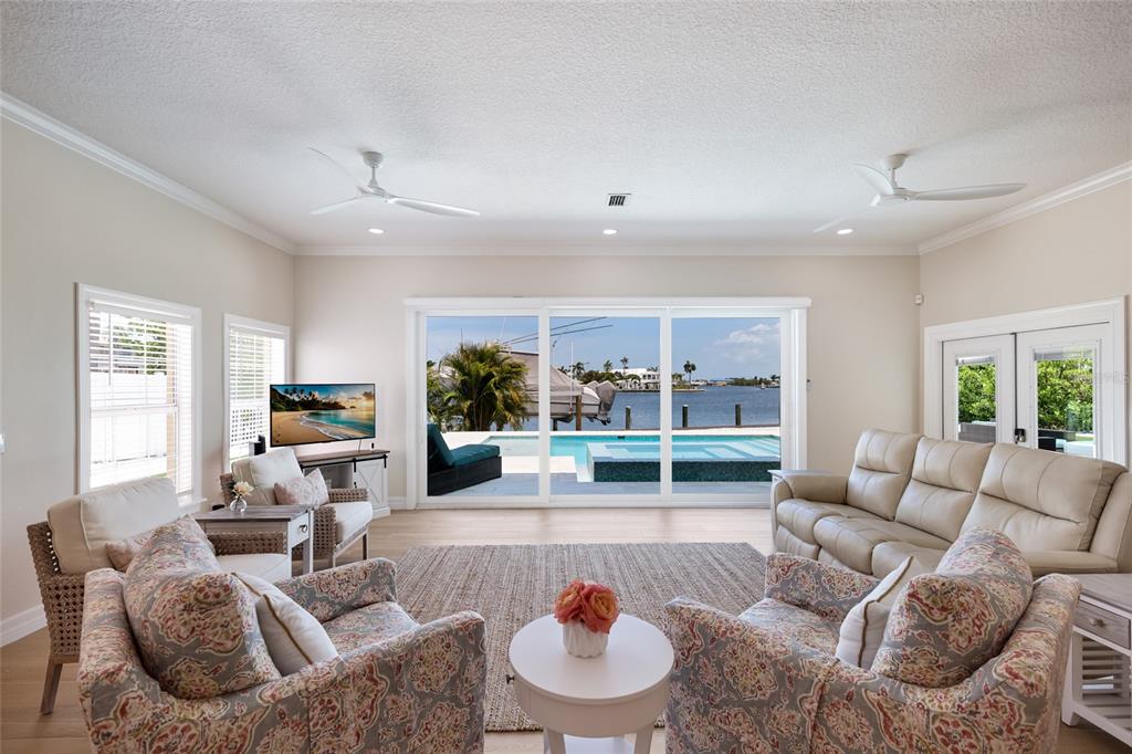 A backyard pool and spa overlook a canal with a boat on a lift — 532 70TH STREET, HOLMES BEACH, FL