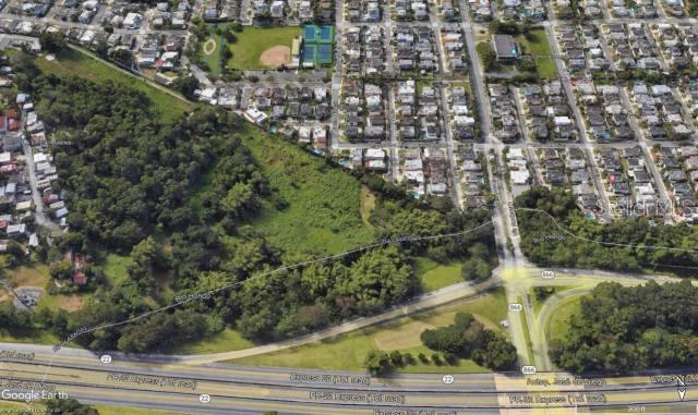 This is an aerial view showing a large vacant lot adjacent to a residential neighborhood — PR-22 INT PR-866, BAYAMON, PR