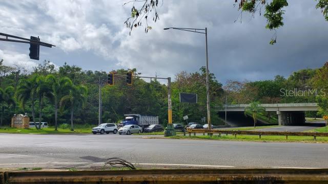 A view of a road intersection with traffic lights, a bridge, and surrounding trees — PR-22 INT PR-866, BAYAMON, PR