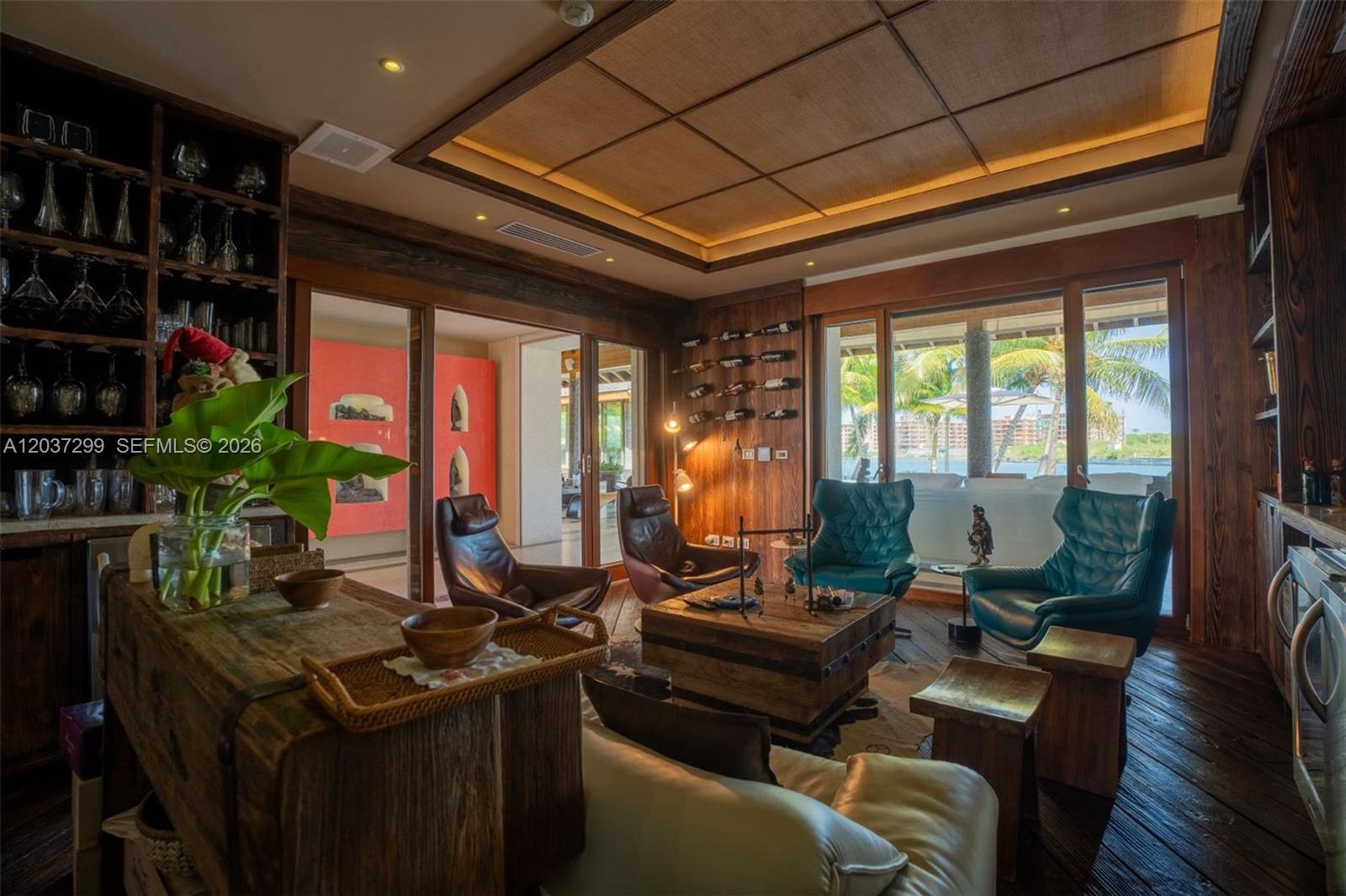 A rustic lounge features wood-paneled walls, a coffered ceiling, leather armchairs, and a view of water — 0 Cap Cana, FL, FL