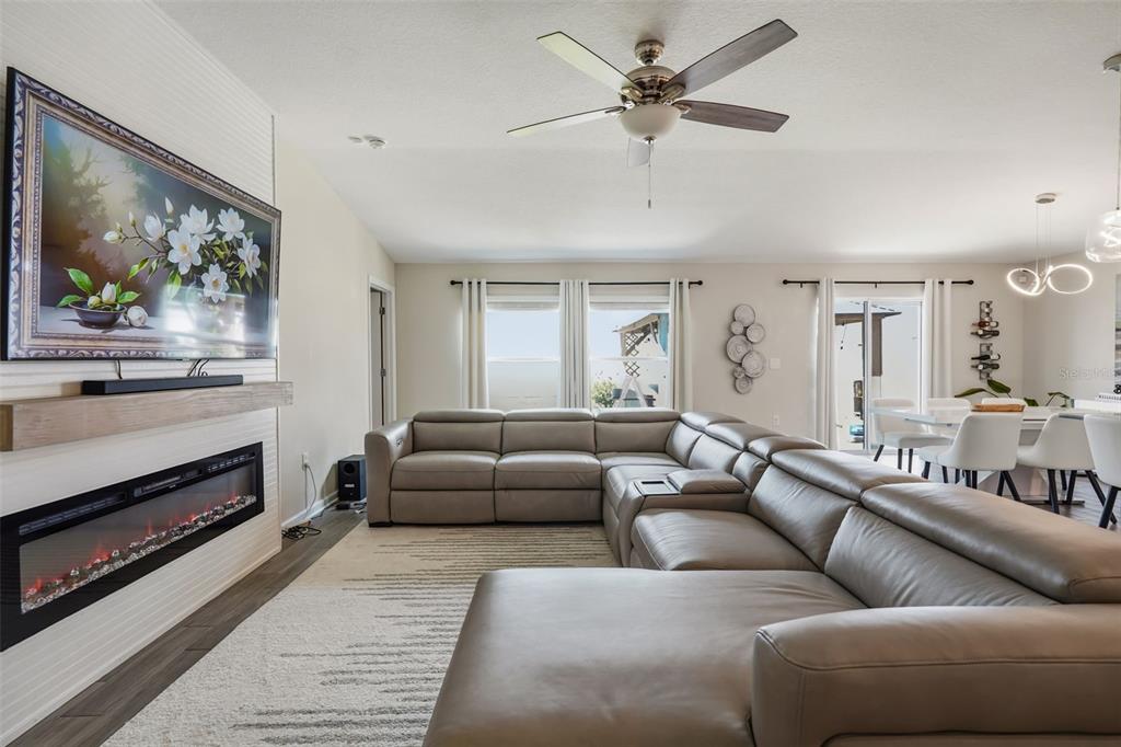 A living room features a large sectional sofa, a fireplace, and a wall-mounted television — 4230 HOLSTEIN STREET, ST CLOUD, FL