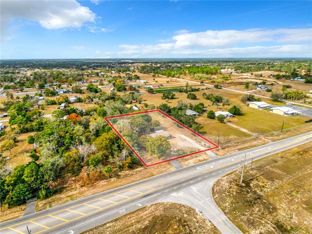 An aerial view shows a rectangular property lot outlined in red beside a paved road — 9421 SUNSHINE GROVE ROAD, BROOKSVILLE, FL