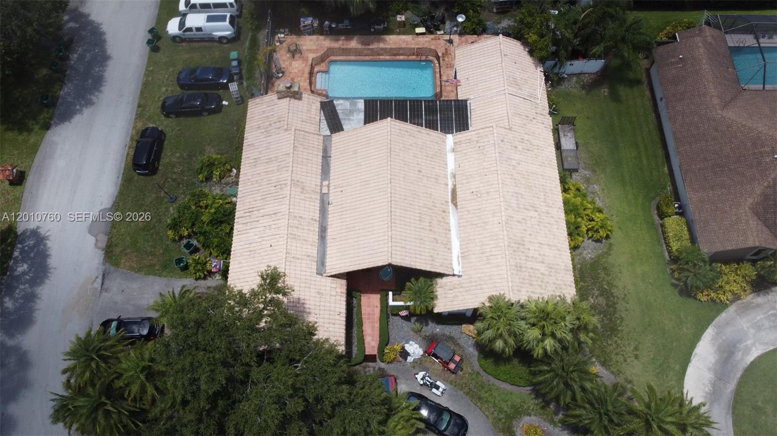 An aerial view shows a house with a tiled roof, a swimming pool, and multiple vehicles — 10500 SW 126th St, Miami FL 33176, MIAMI, FL