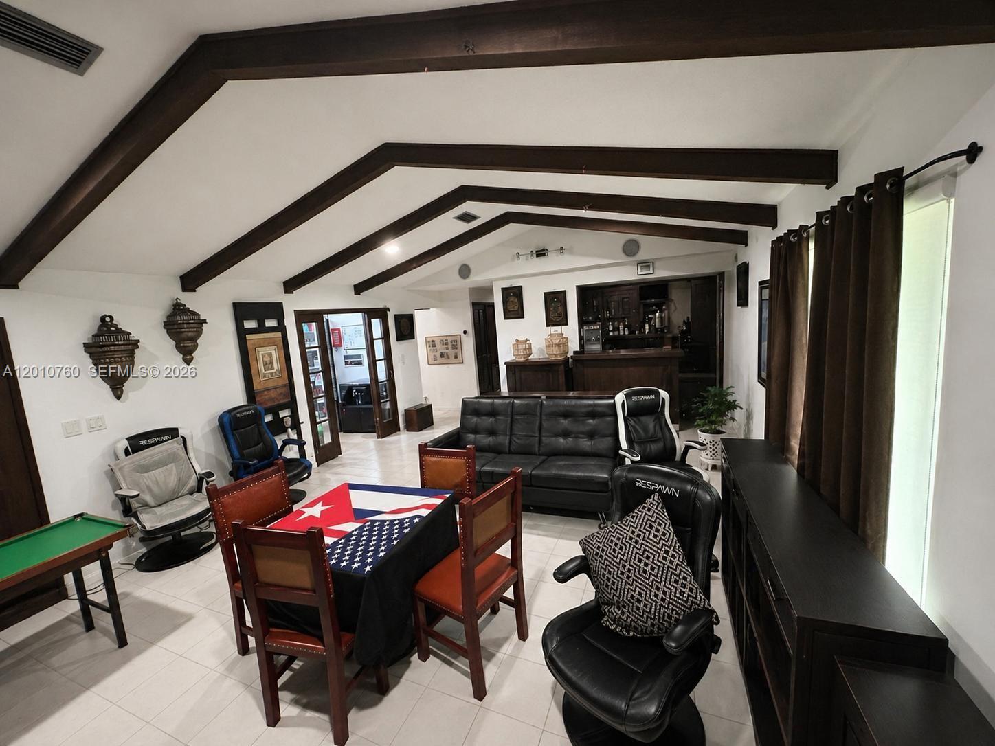 A living area features vaulted ceilings with exposed beams, a bar, and gaming chairs — 10500 SW 126th St, Miami FL 33176, MIAMI, FL