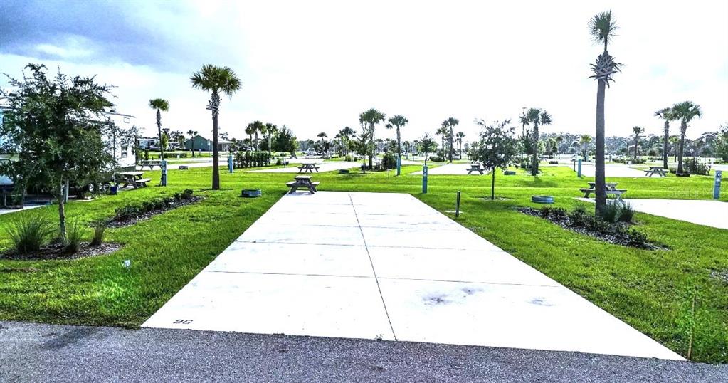 A concrete RV pad sits on a grassy lot with palm trees and picnic tables — 96 CR-630 E, LAKE WALES, FL