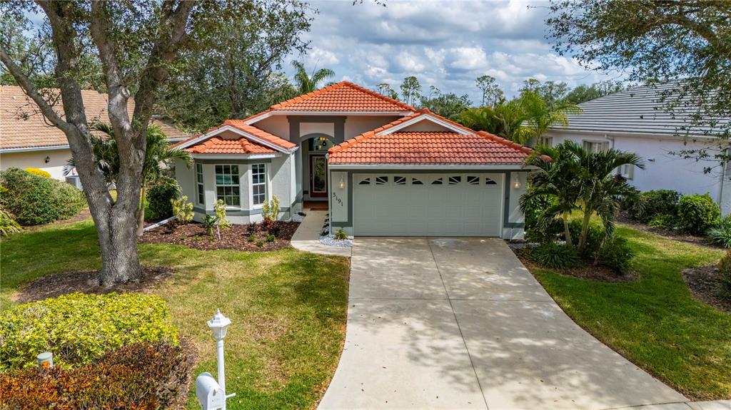 A single-story house with a tiled roof, two-car garage, and a concrete driveway — 3191 VILLAGE LANE, PORT CHARLOTTE, FL