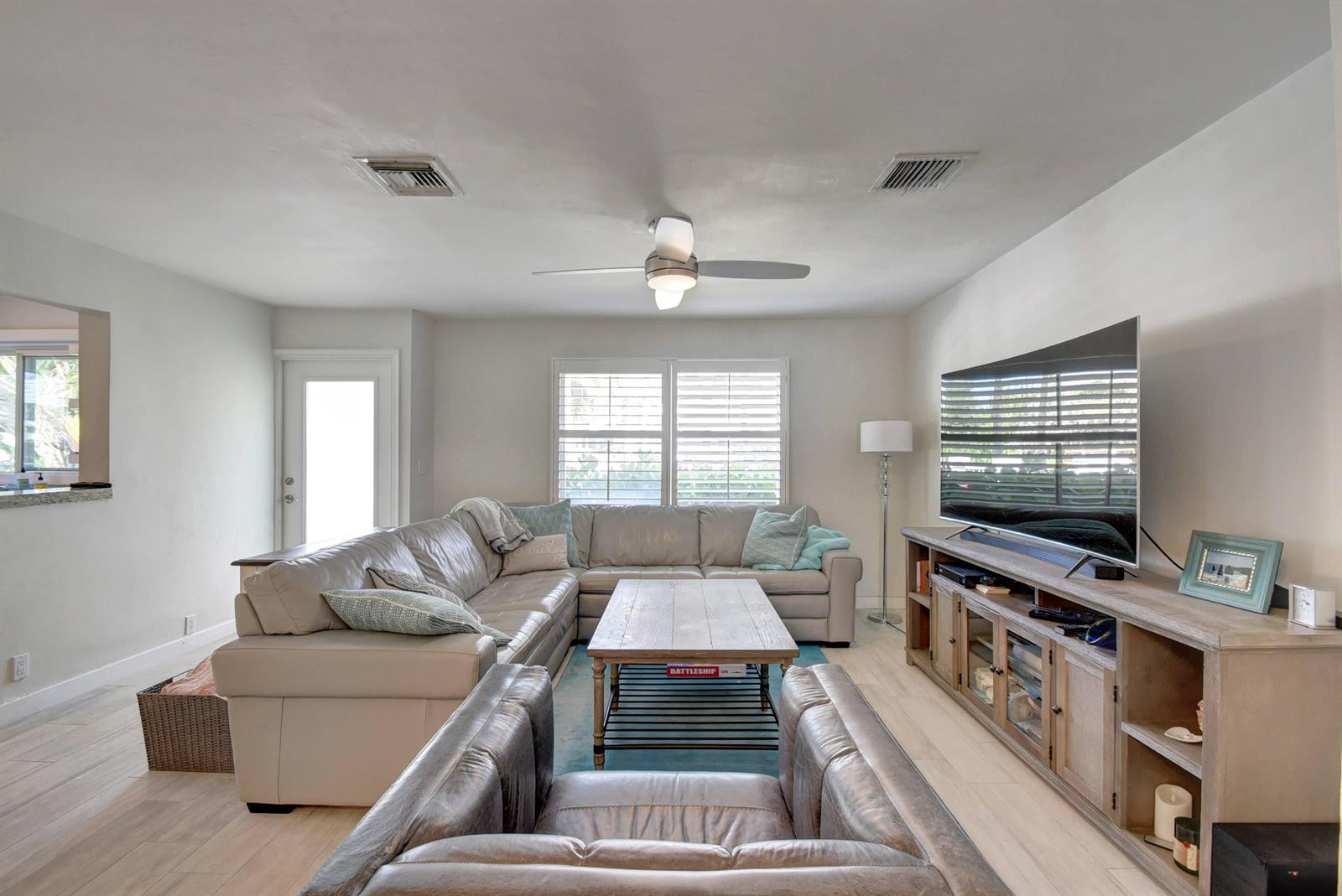 A living room features a large sectional sofa, a coffee table, and a television console — 1020 Casuarina Road, Delray Beach FL 33483, DELRAY BEACH, FL