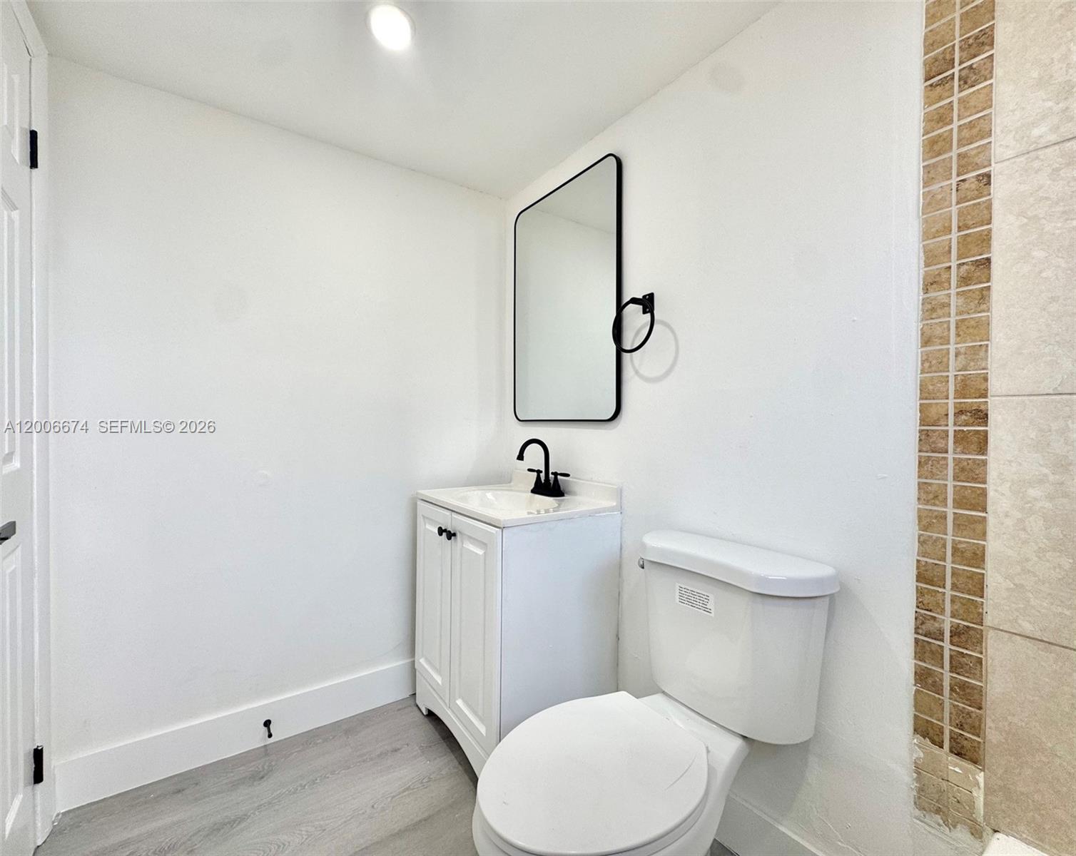 A bathroom features a white vanity, a black-framed mirror, and a white toilet — 417 NW 2nd Ave # 000, Hallandale Beach FL 33009, HALLANDALE BEACH, FL