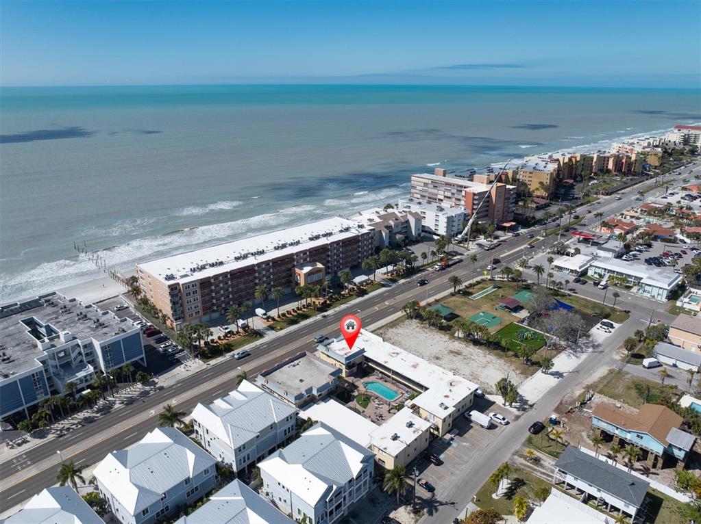 An aerial view shows a coastal hotel with a pool, near a beach and road — 16333 GULF BOULEVARD UNIT 201, REDINGTON BEACH, FL
