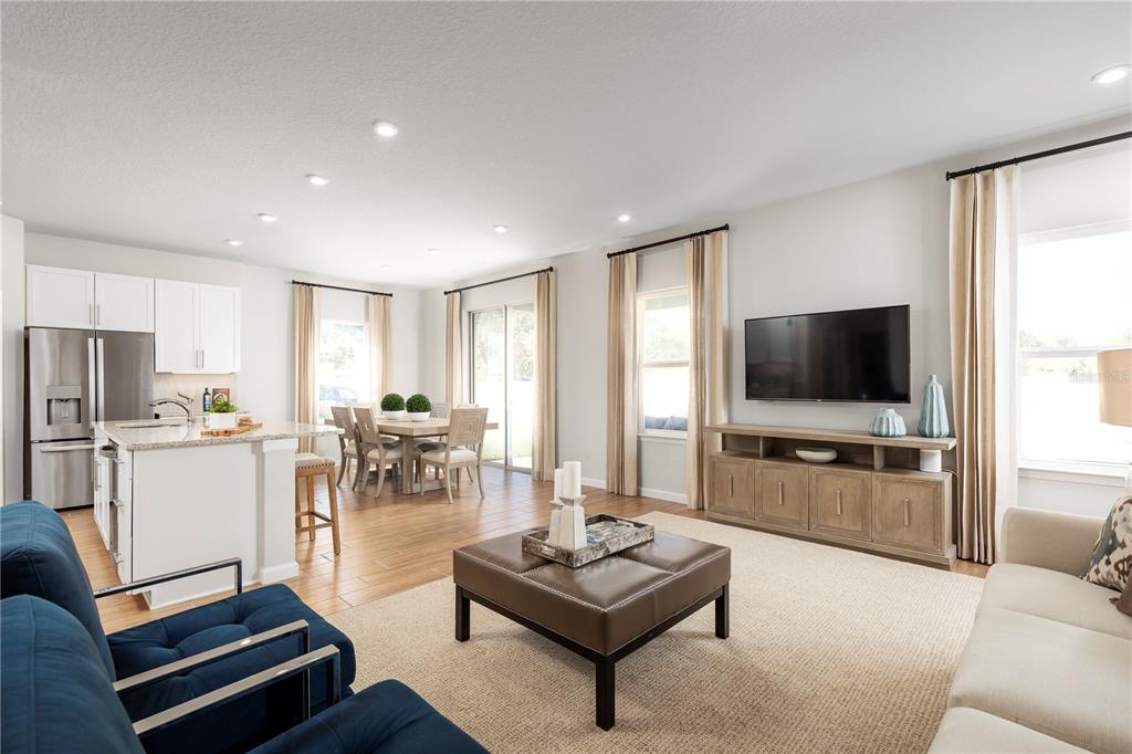 An open-concept living room and kitchen featuring tile flooring, a dining area, and neutral decor — 2207 GREAT EGRET CIRCLE, OCOEE, FL