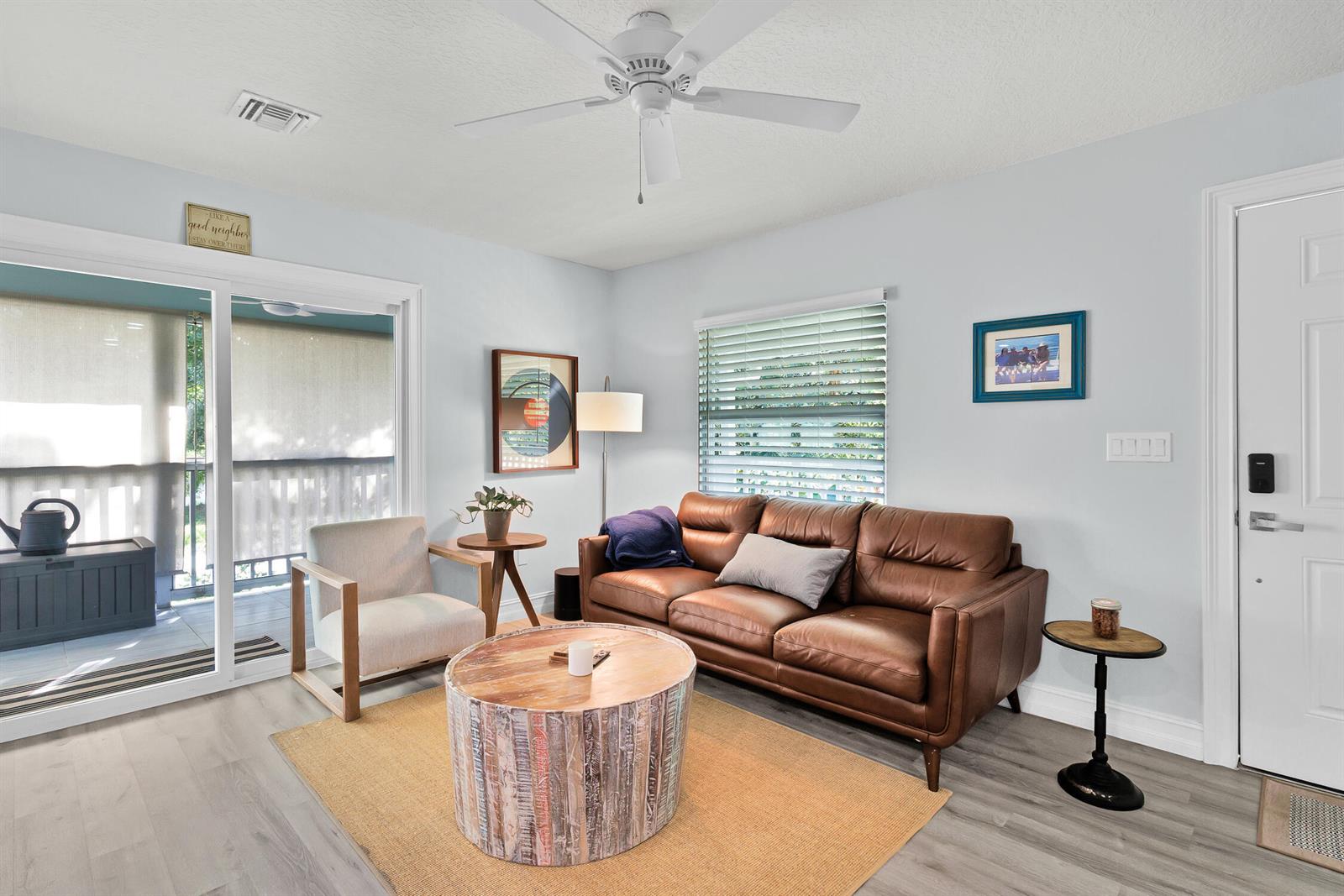 A living room features a brown leather sofa, a round wooden coffee table, and light flooring — FELLSMERE, FL