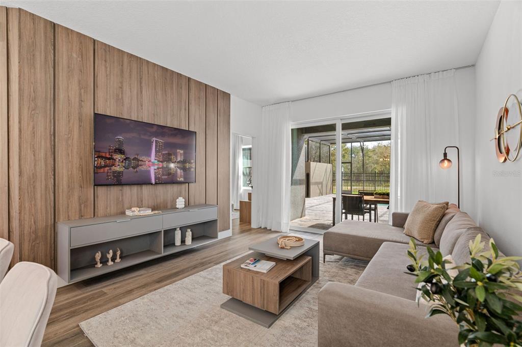 A living room features a wood-paneled accent wall, a gray media console, and sliding glass doors — 9084 BORACAY COURT, KISSIMMEE, FL