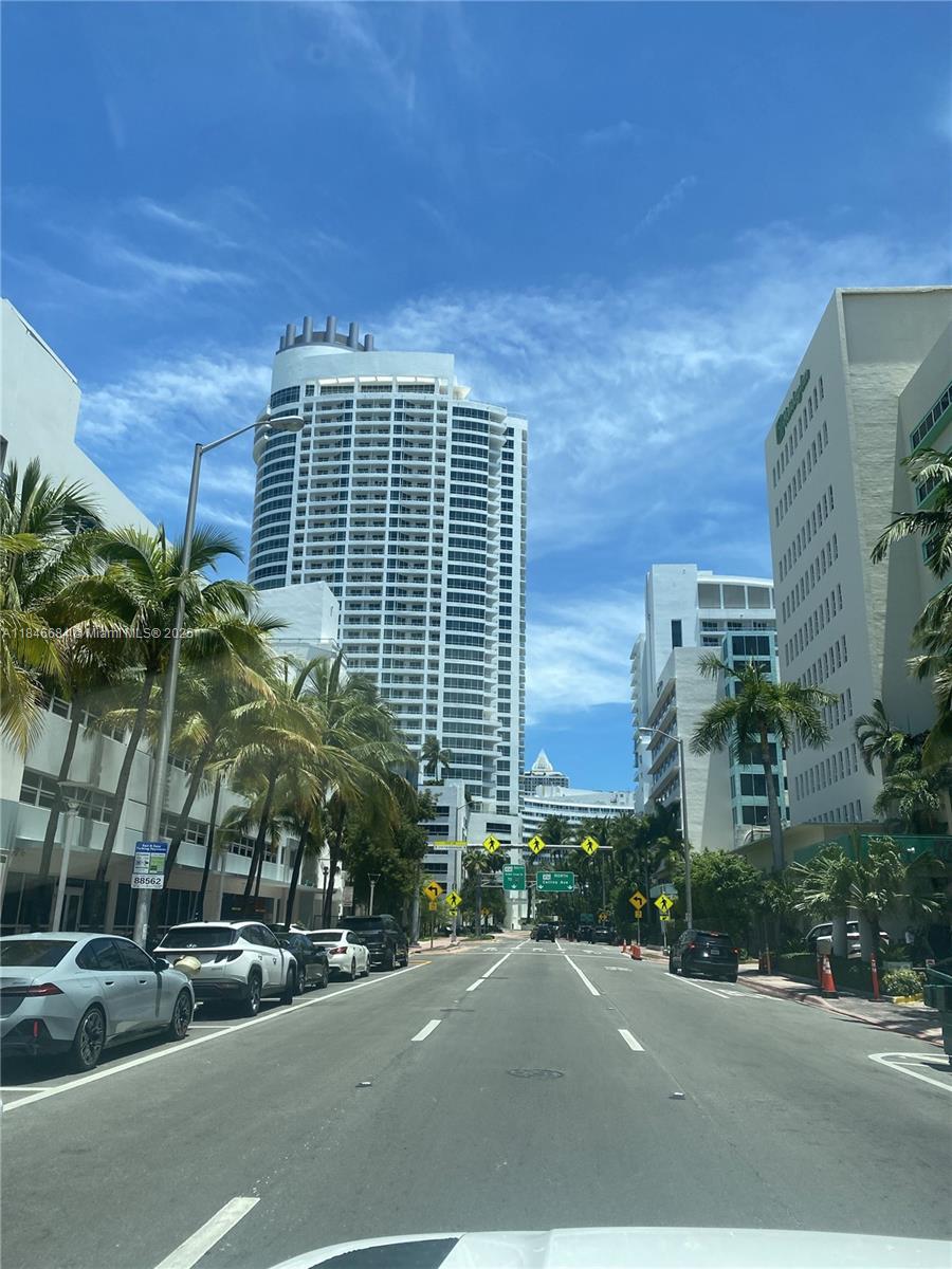 A street view looking down a road lined with palm trees and tall buildings — 4401 Collins Ave, Miami Beach FL 33140, MIAMI BEACH, FL